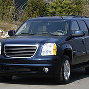 Black SUV parked outdoors on a road with trees in the background