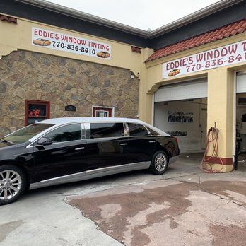 Black hearse parked outside Eddie’s Window Tinting storefront and garage bay