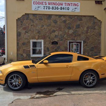 Yellow sports car parked outside Eddie’s Window Tinting shop.