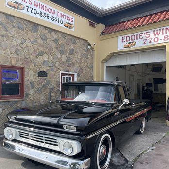 Black classic Chevy pickup parked outside Eddie’s Window Tinting shop.