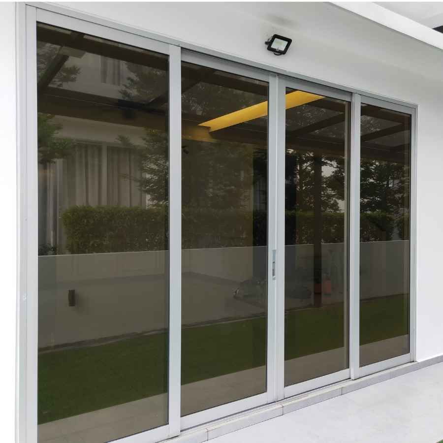 Sliding glass patio doors with dark-tinted panels on a white exterior wall
