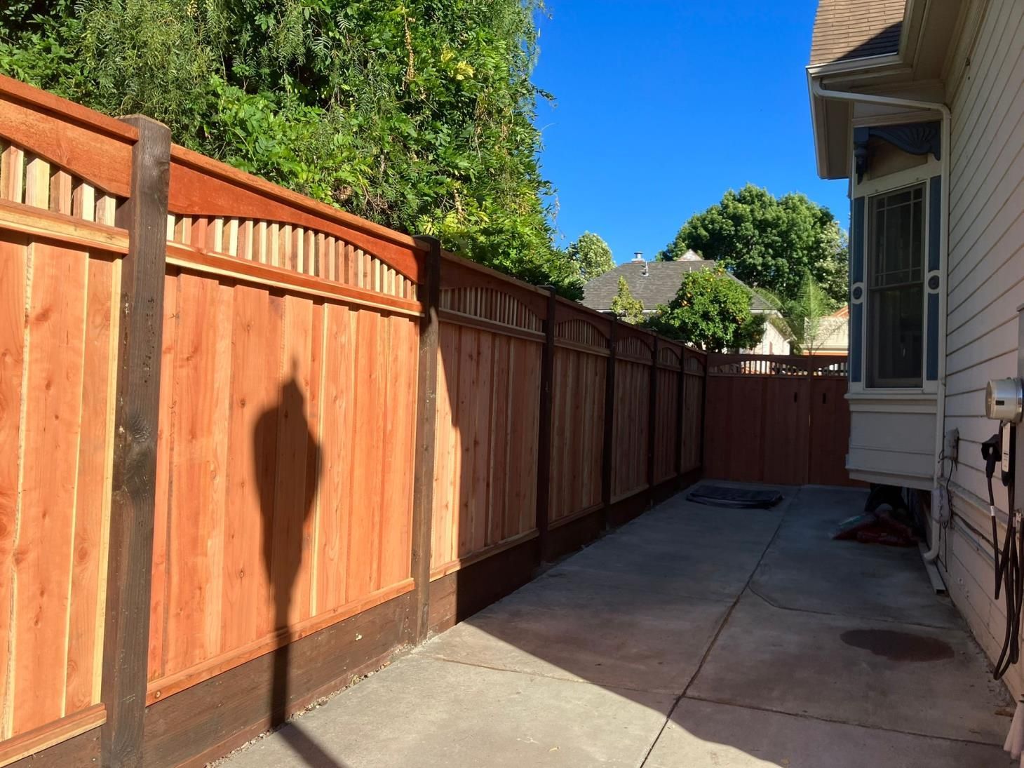 Freshly installed cedar wood fencing running along the yard, providing a natural and appealing boundary.