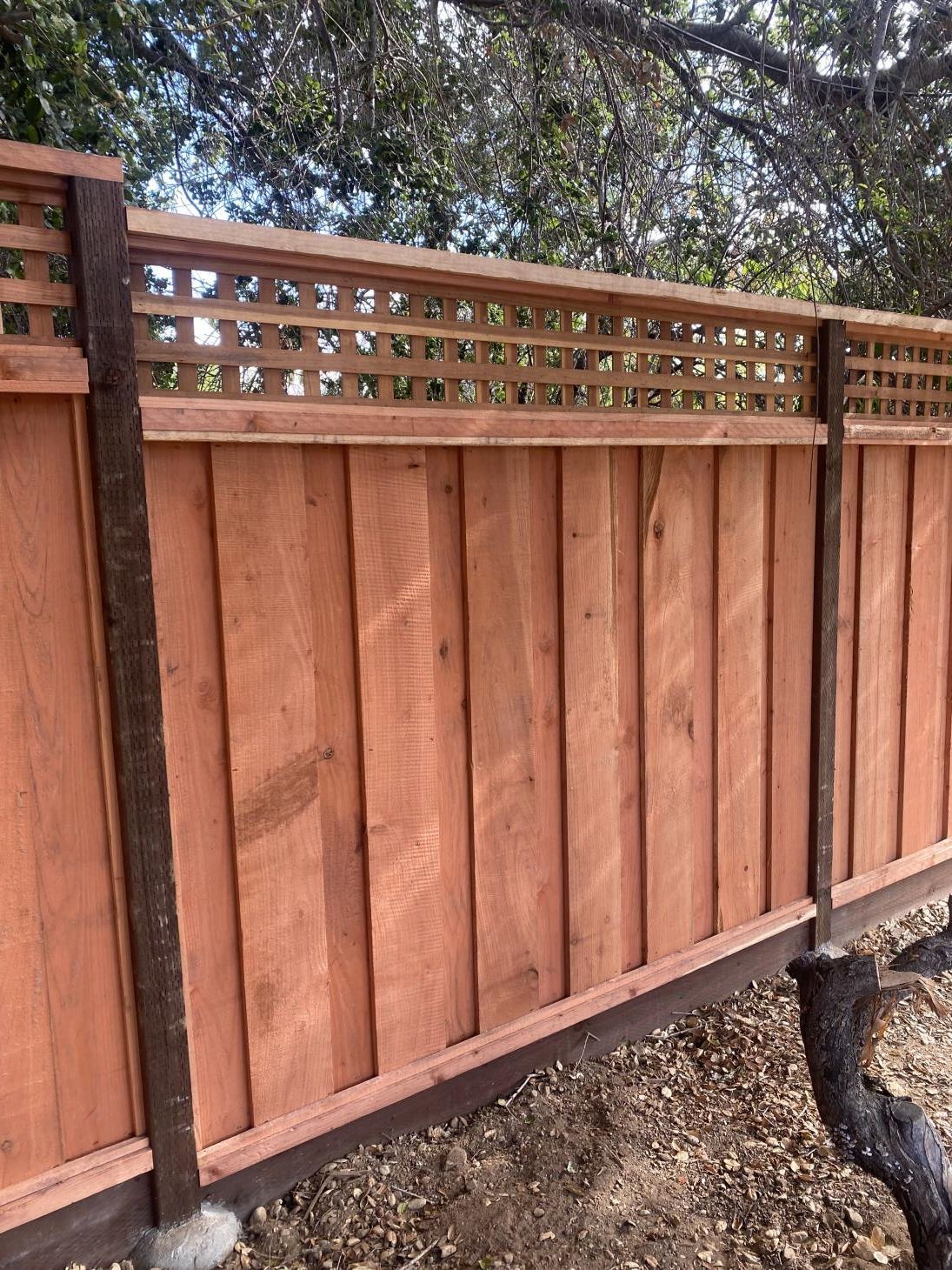 Aged wooden fence near new lumber boards.