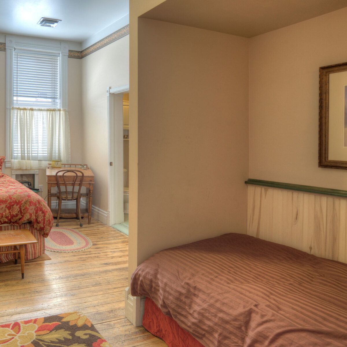 A room with a single bed, desk, and window