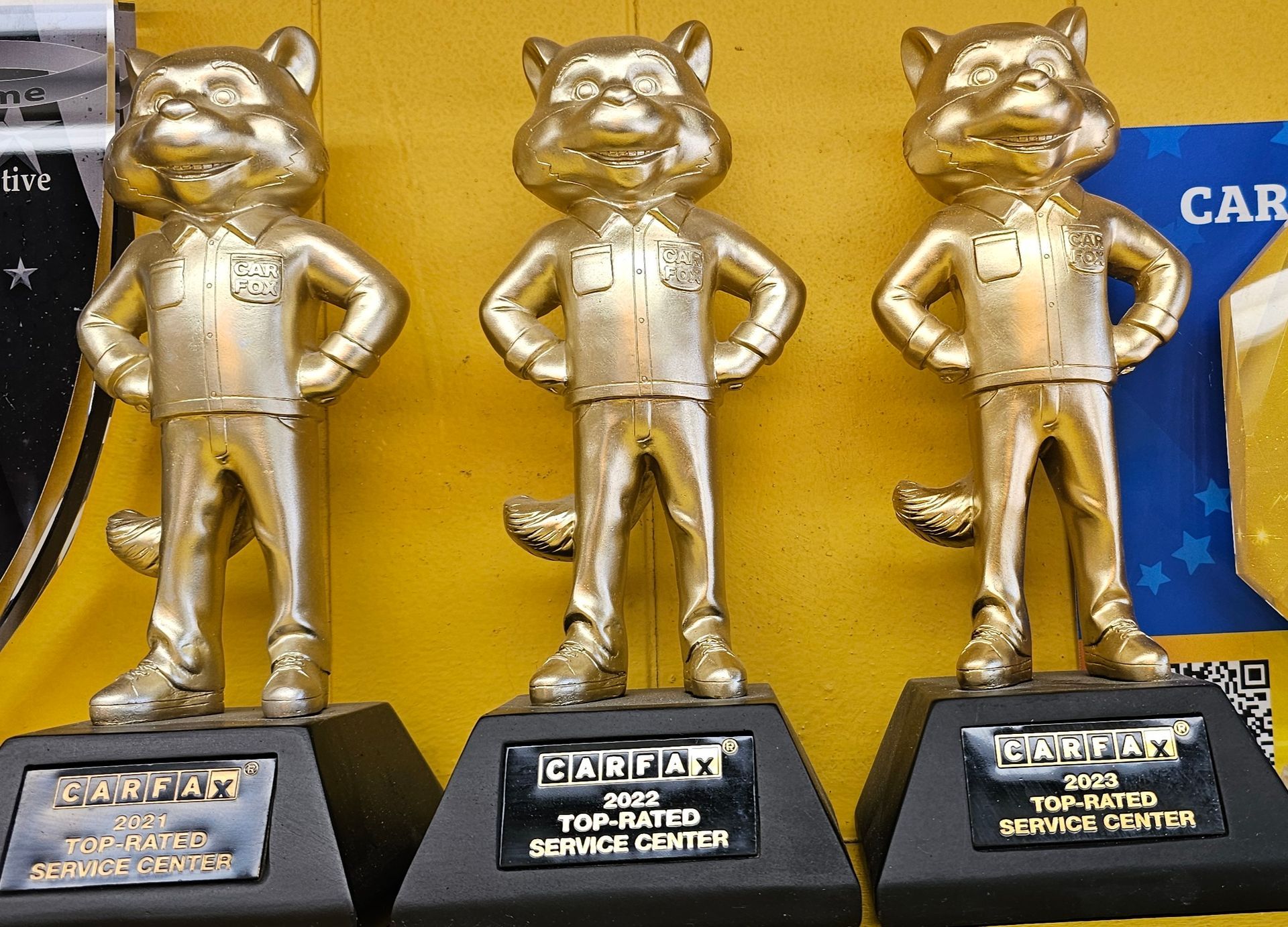 Three gold bobcat trophies on black bases, labeled 