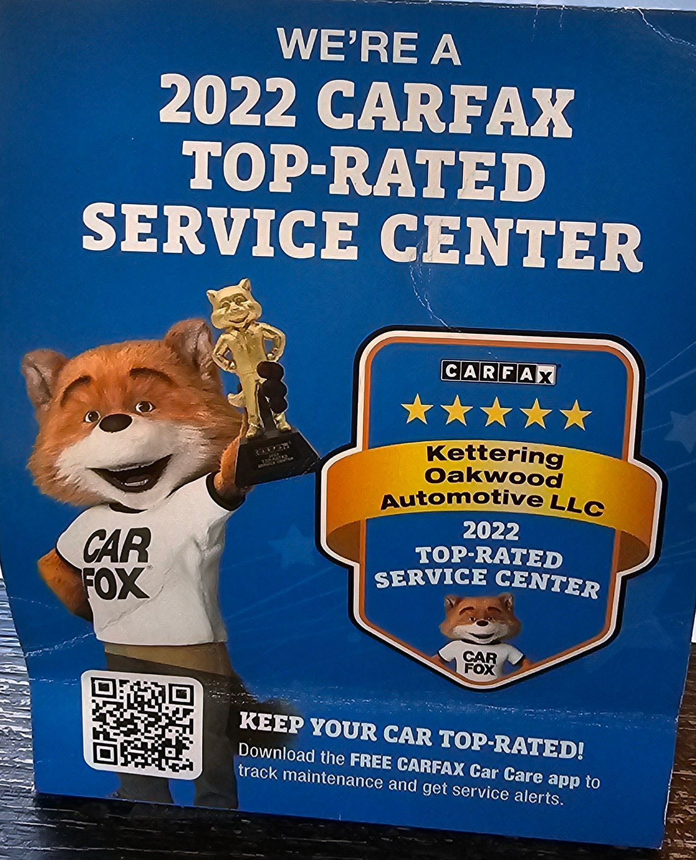 A promotional sign announcing Kettering Oakwood Automotive LLC as a 2022 Carfax Top-Rated Service Center.