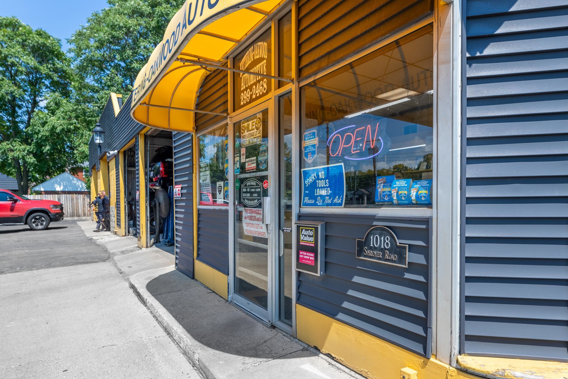 Auto repair shop with yellow awning, glass door, and 
