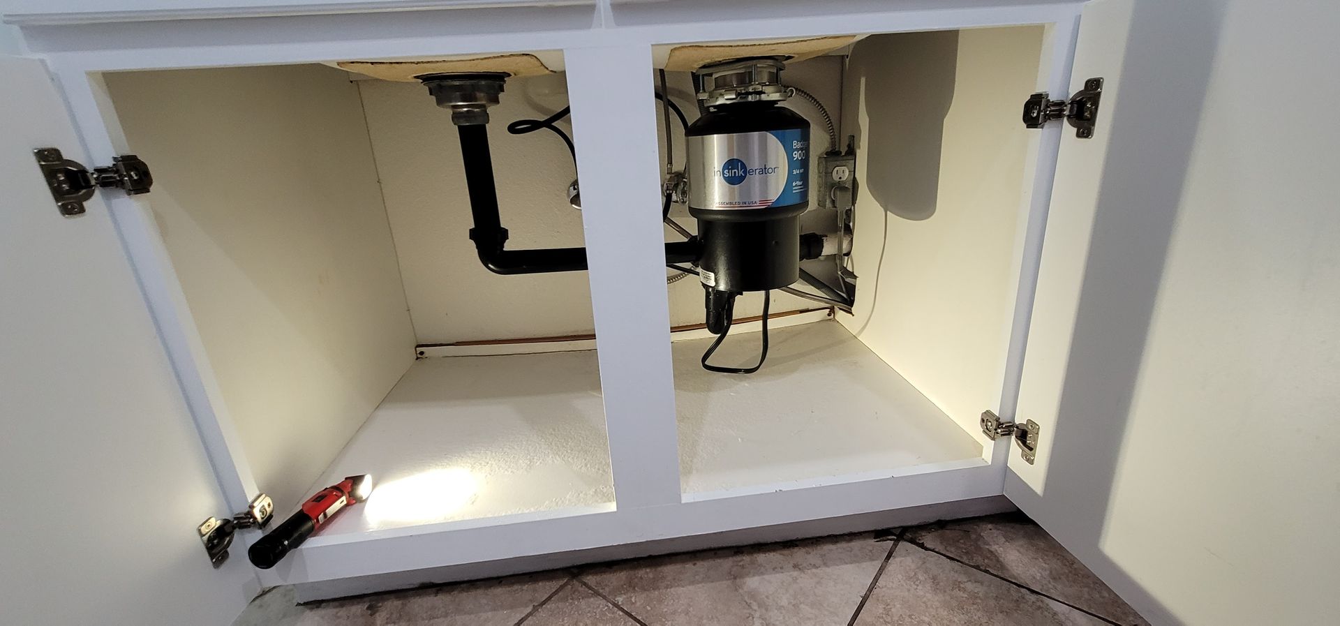 There is a garbage disposal under the sink in the cabinet.