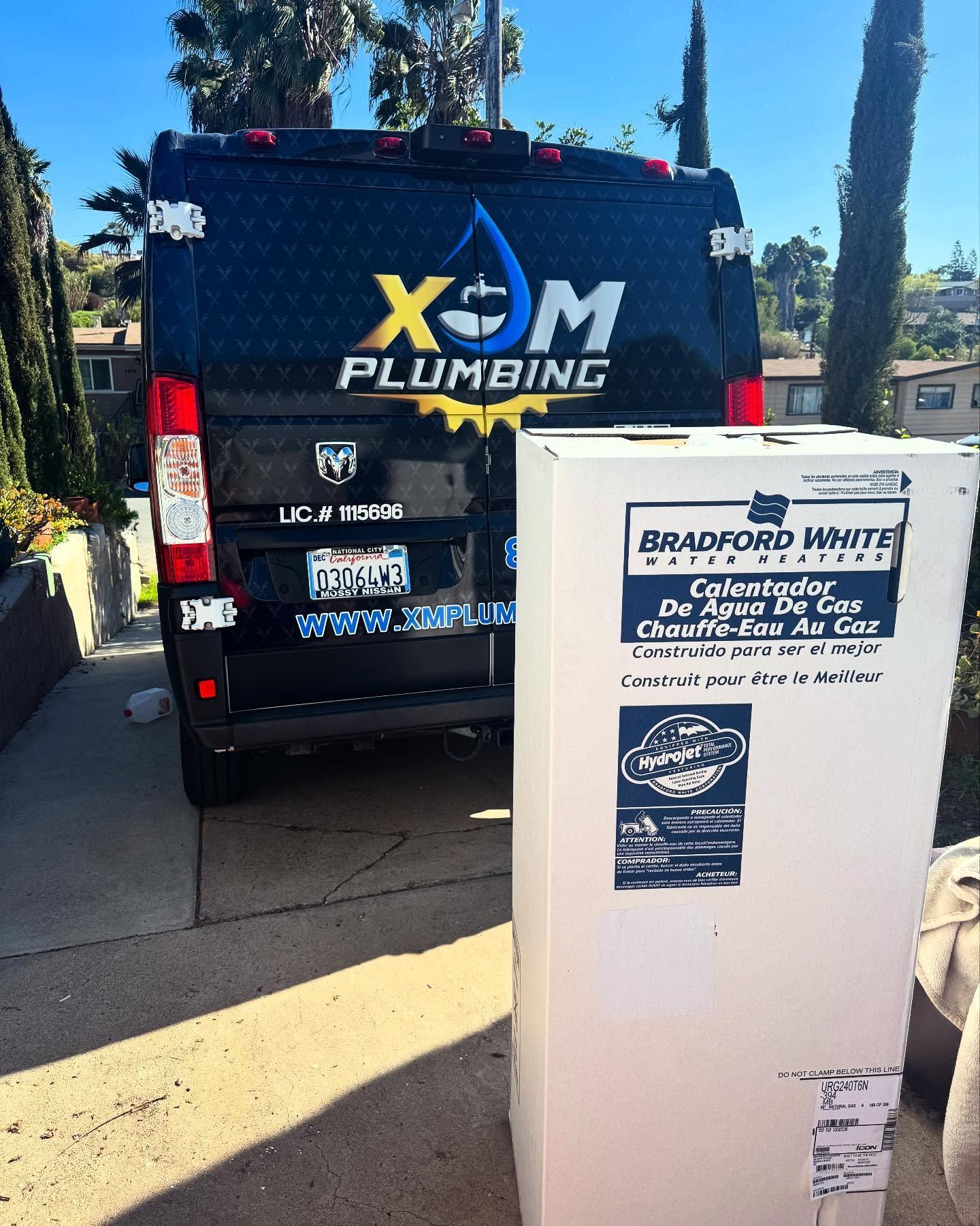 A x-m plumbing van is parked next to a box