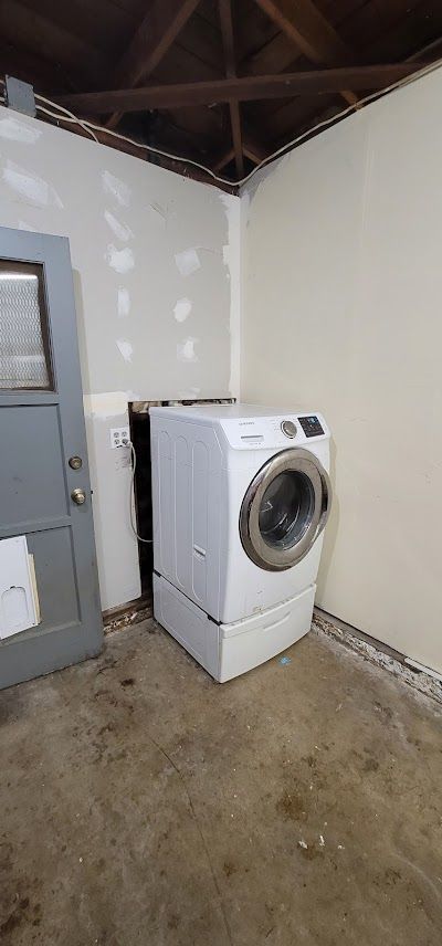 A washer and dryer are sitting in a laundry room next to a door.