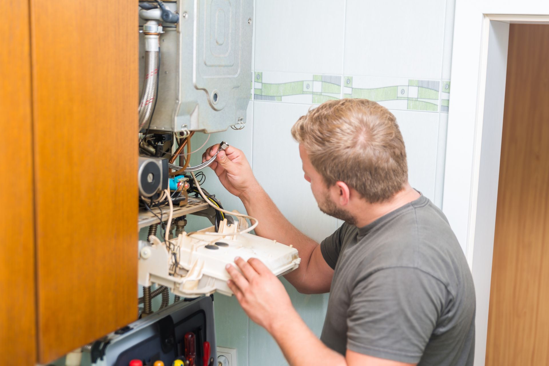 A man is inspecting a gas furnace.