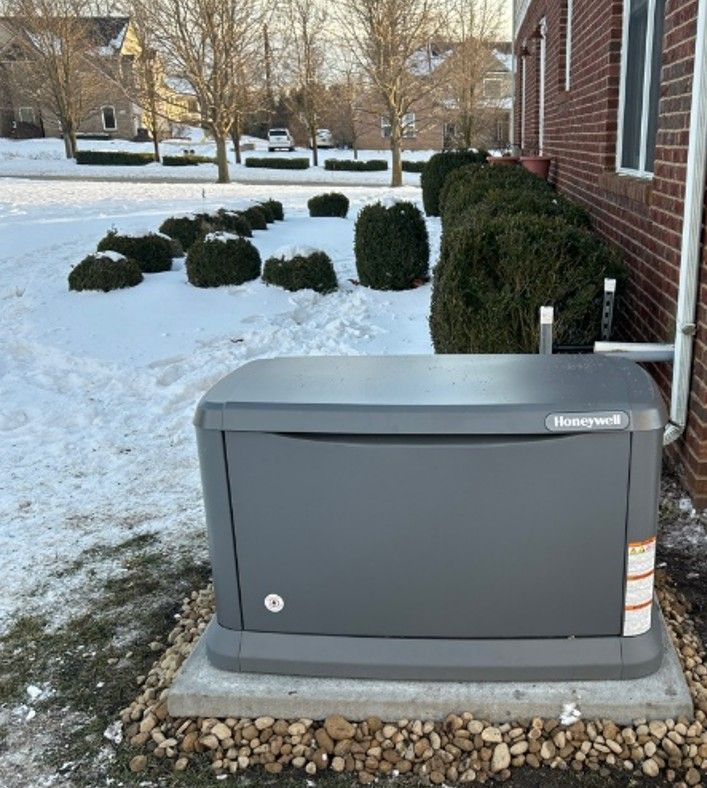 Standby generator installed on a concrete pad next to a residential home
