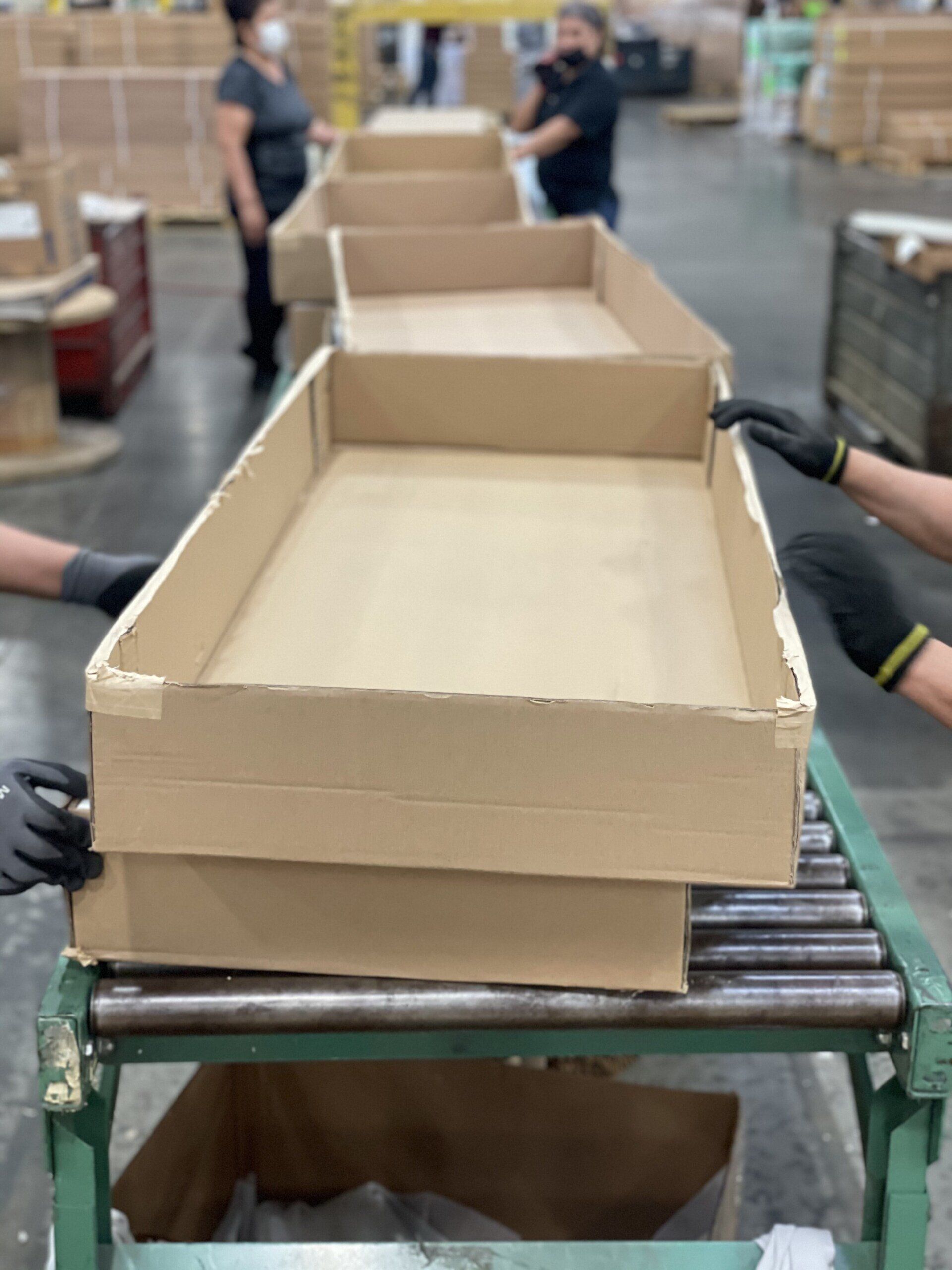 A row of cardboard boxes stacked on top of each other on a conveyor belt