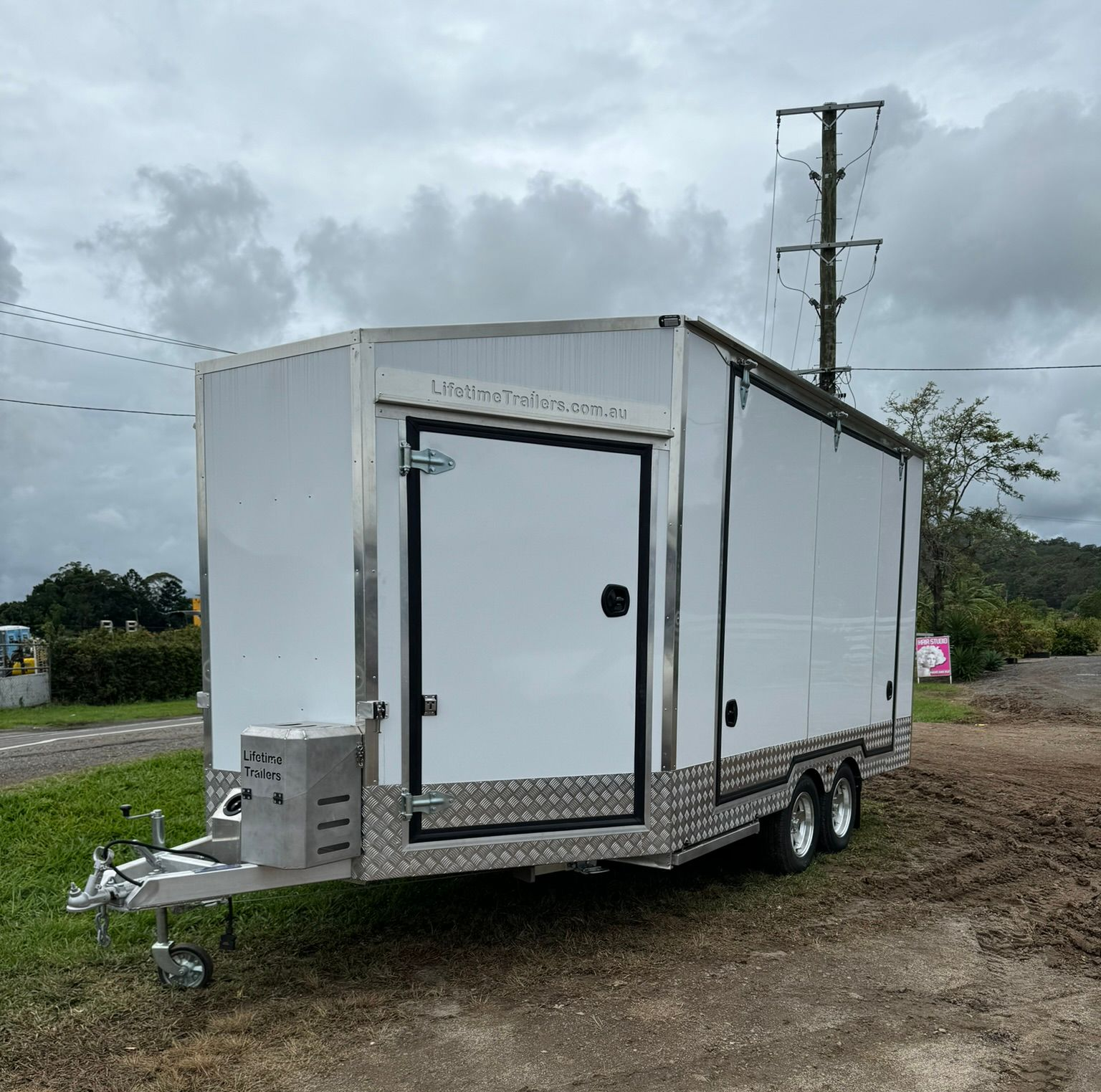 Gray Utility Trailer With Canvas Cover, Parked Outside — Rod's Engineering & Lifetime Trailers in Bli Bli, QLD