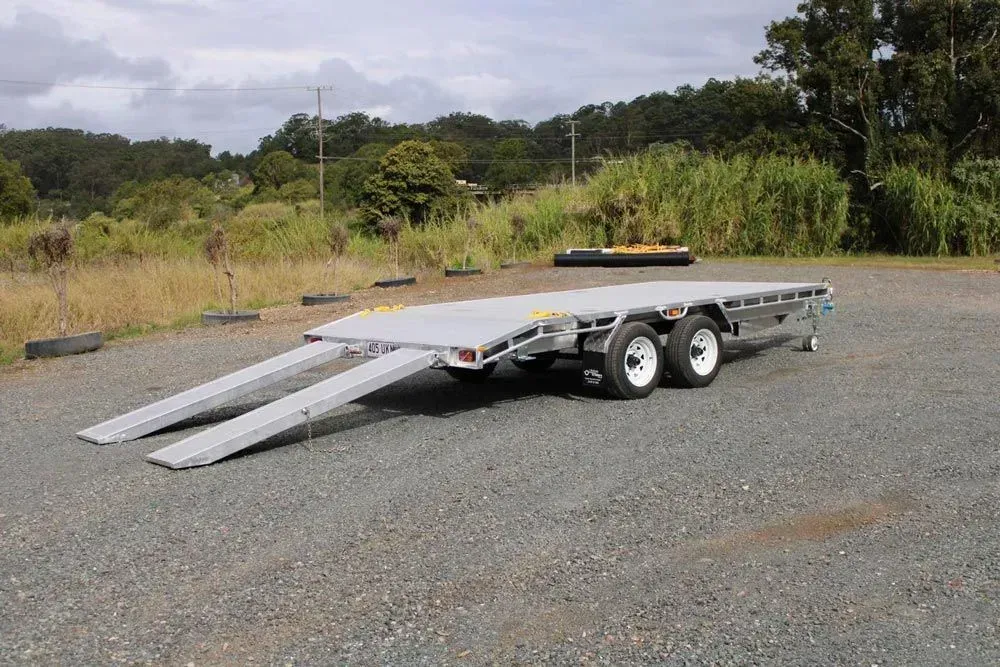 Car Trailer With Lowered Ramps on a Gravel Lot — Rod's Engineering & Lifetime Trailers in Bli Bli, QLD