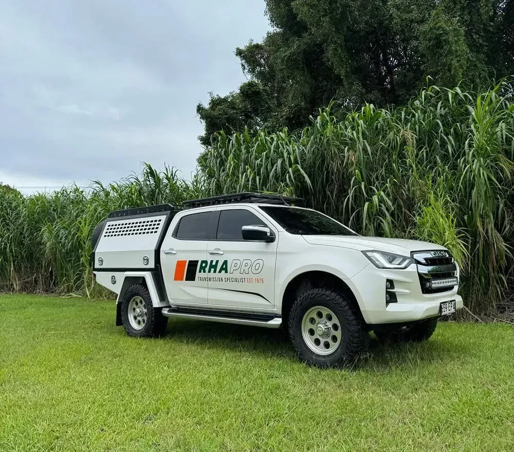 White Isuzu D-max Truck With a Canopy Parked on a Grassy Field — Rod's Engineering & Lifetime Trailers in Bli Bli, QLD