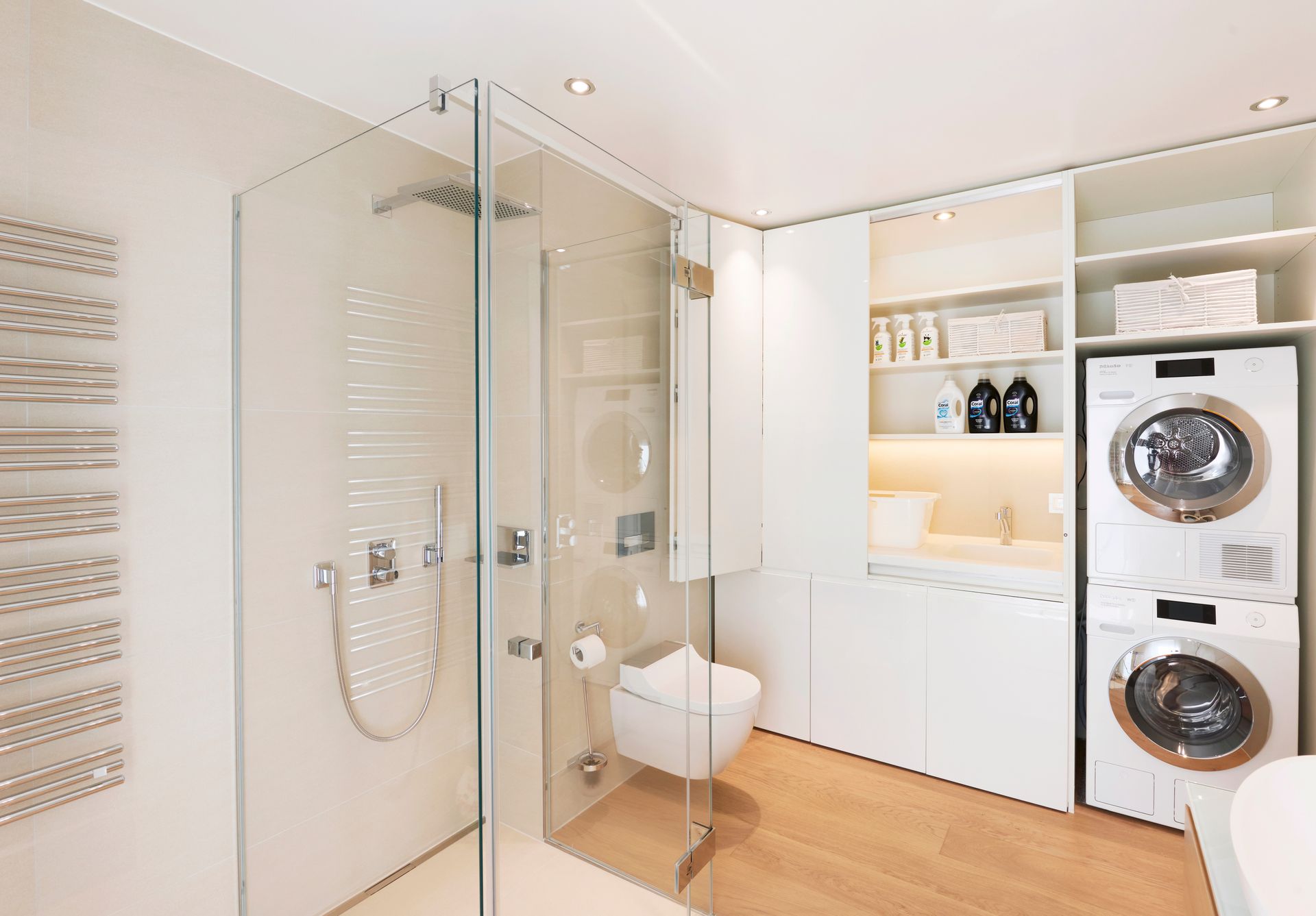 A bathroom featuring a glass door shower, stacked washer and dryer, and tiled walls.