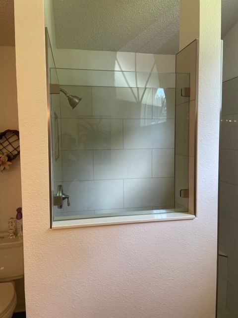 Shower enclosure with glass doors and tile, built into a bathroom wall.