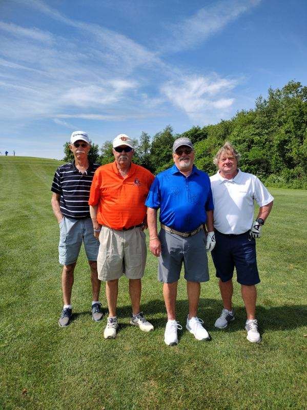 A group of men are posing for a picture on a golf course.
