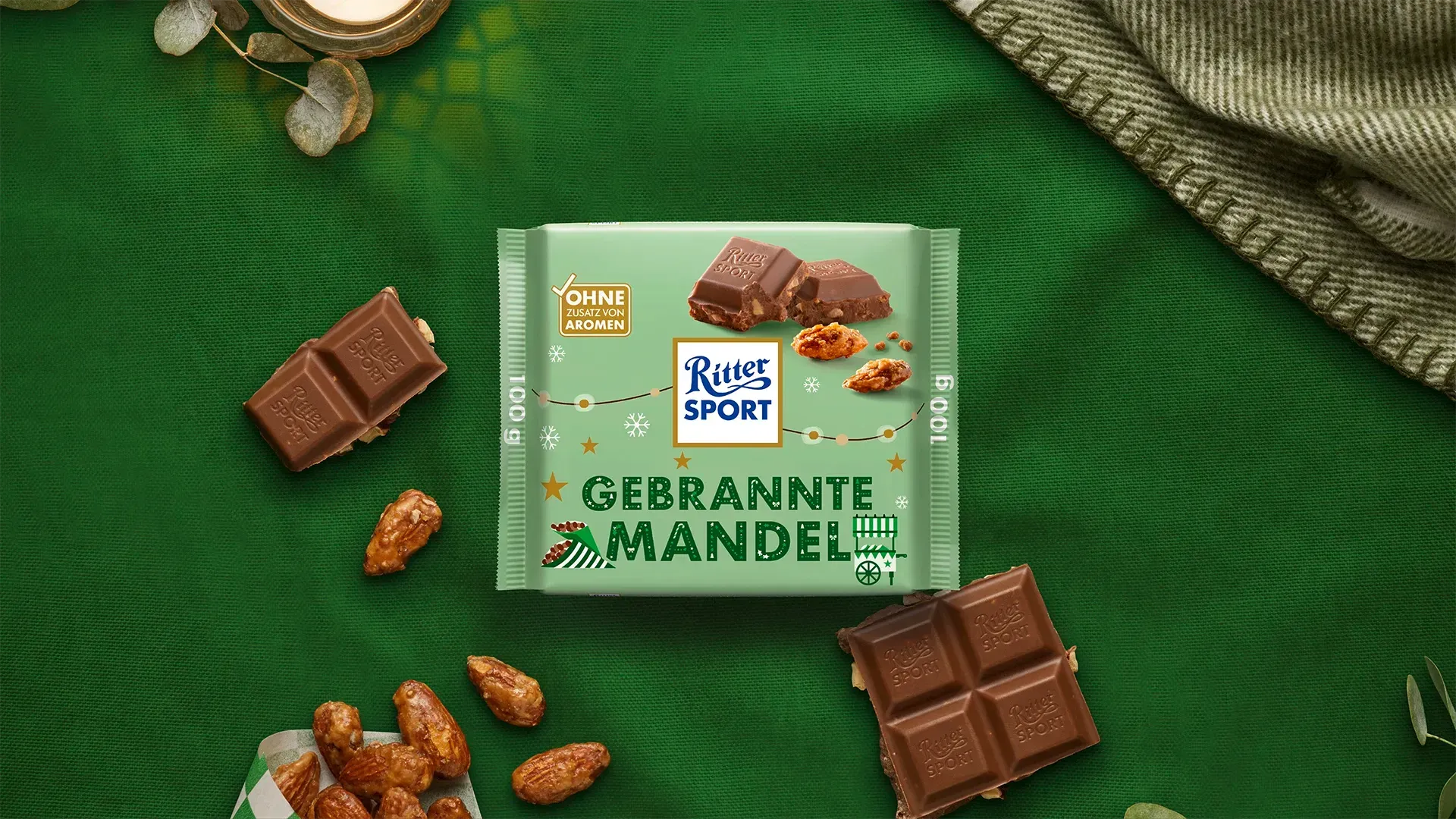 Grüne, pyramidenförmige Geschenkbox mit festlicher roter und goldener Dekoration auf dunkelgrünem Hintergrund. 
Bild wurde mithilfe von KI erstellt.