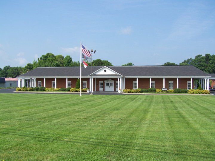 Brick building with American flag and sign reading “Palmer-Marler” on a sunny lawn.
