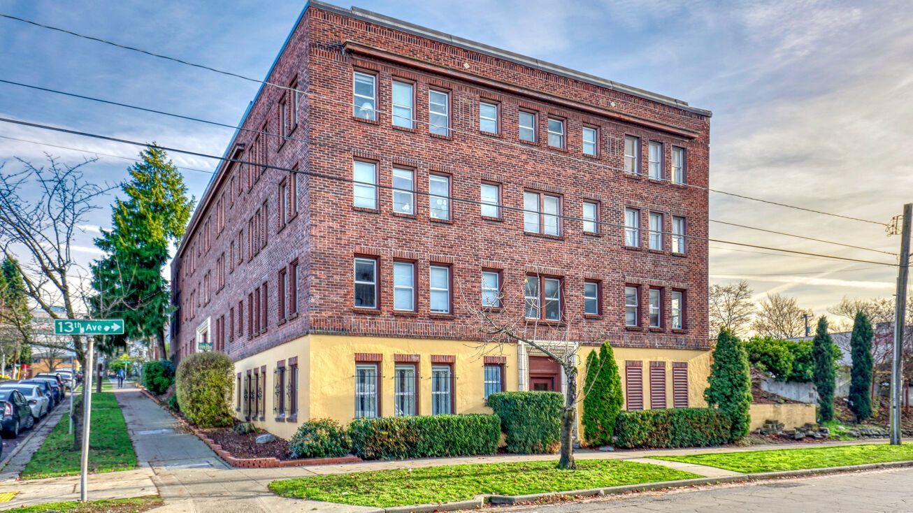 A large building with a lot of windows and a tree in front of it.