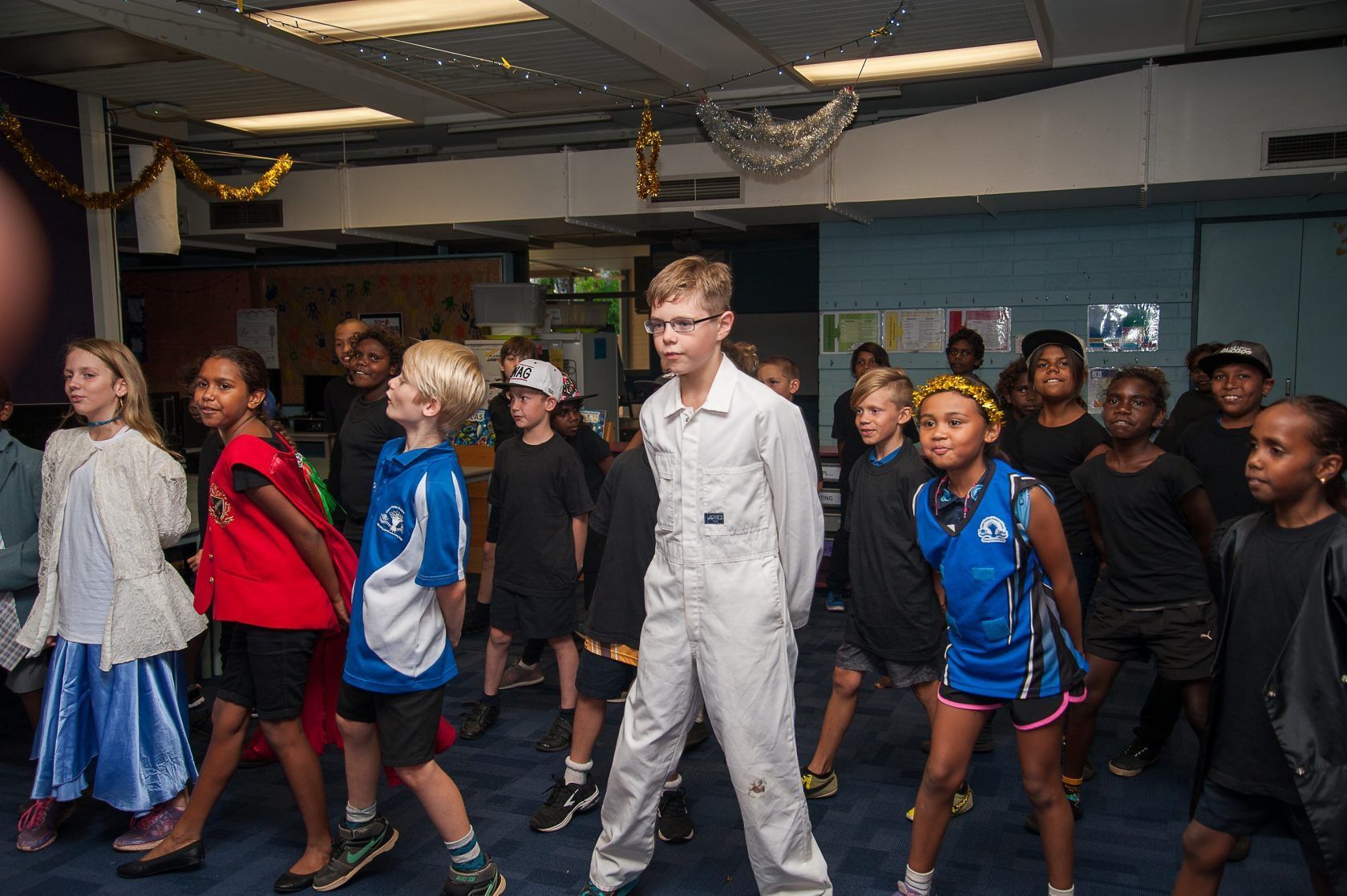 A group of children are dancing together in a room.