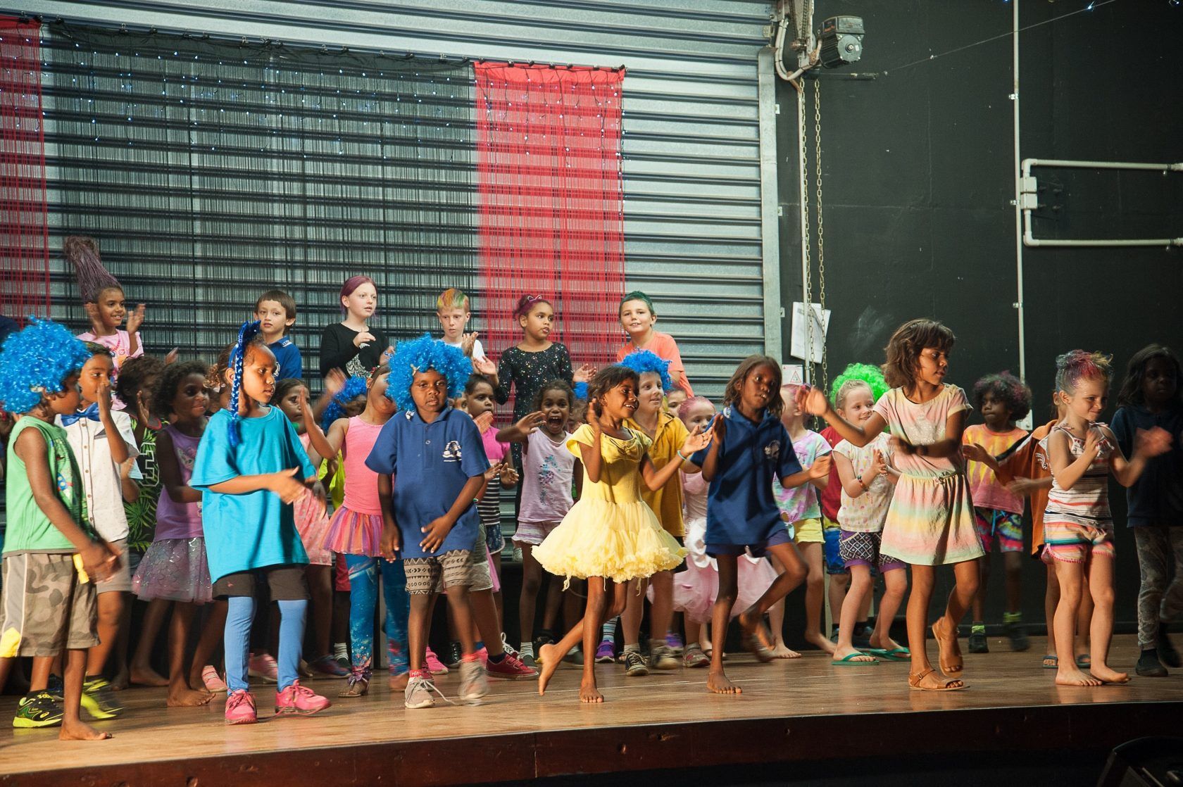 A group of children are dancing on a stage.