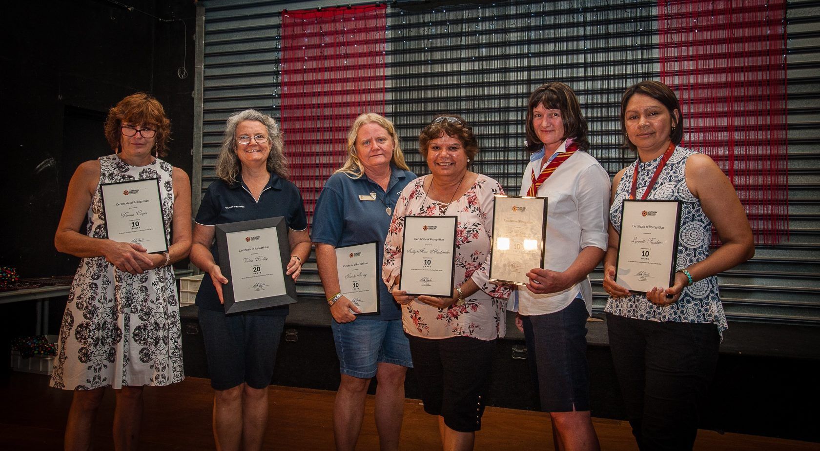 A group of women are standing next to each other holding certificates.