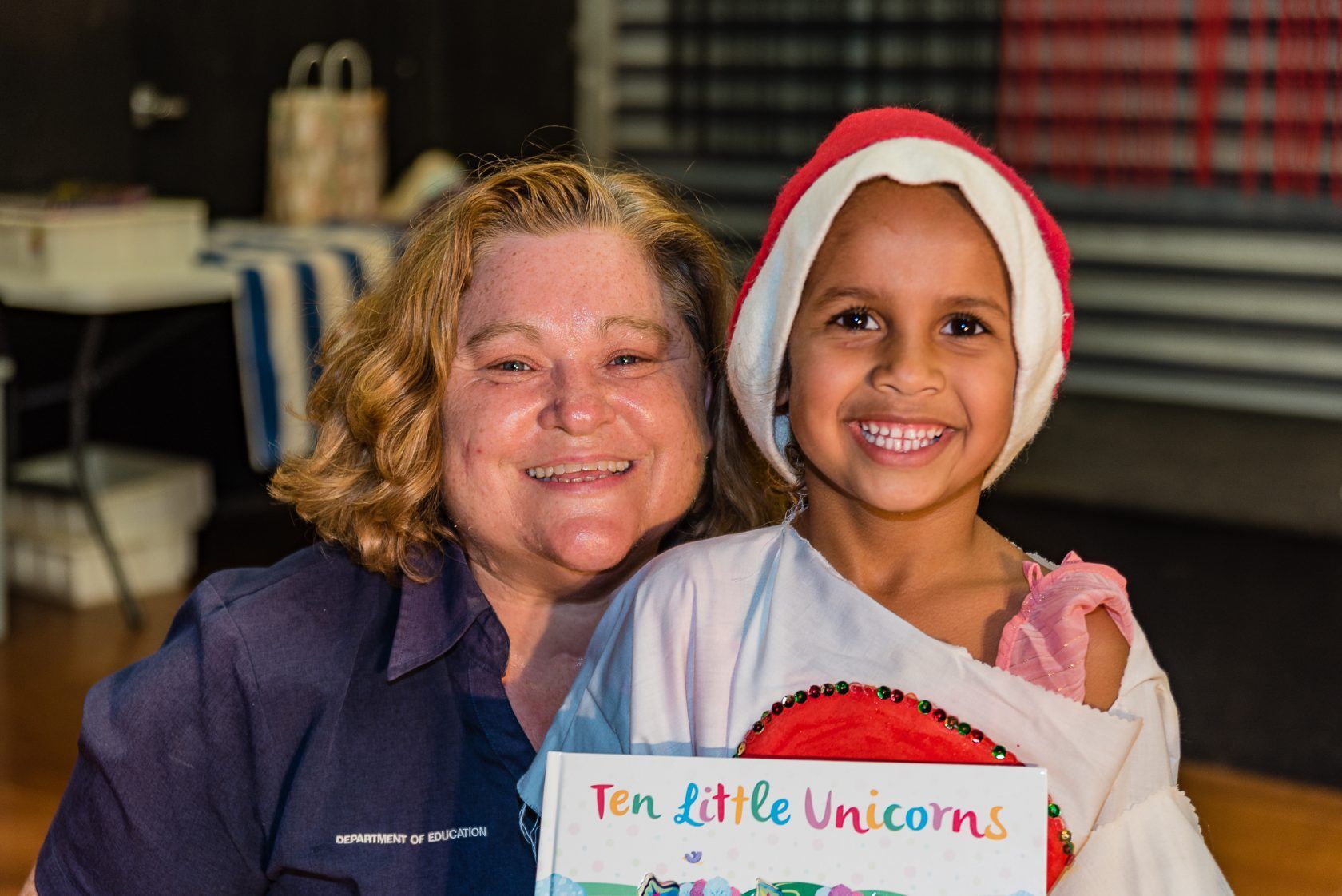 A woman and a little girl are holding a sign that says ten little unicorns.