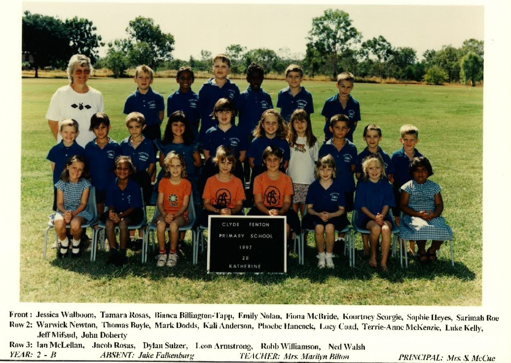 A group of children are posing for a picture in a field