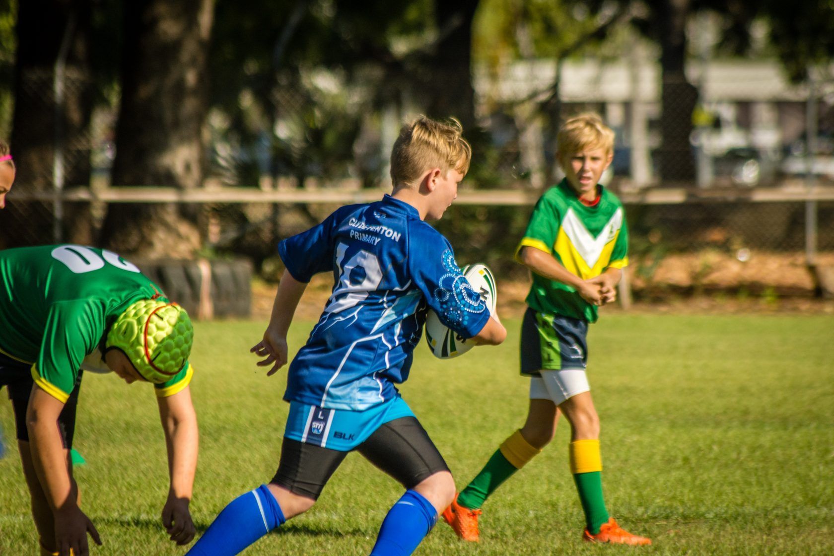 A group of young boys are playing rugby on a field.