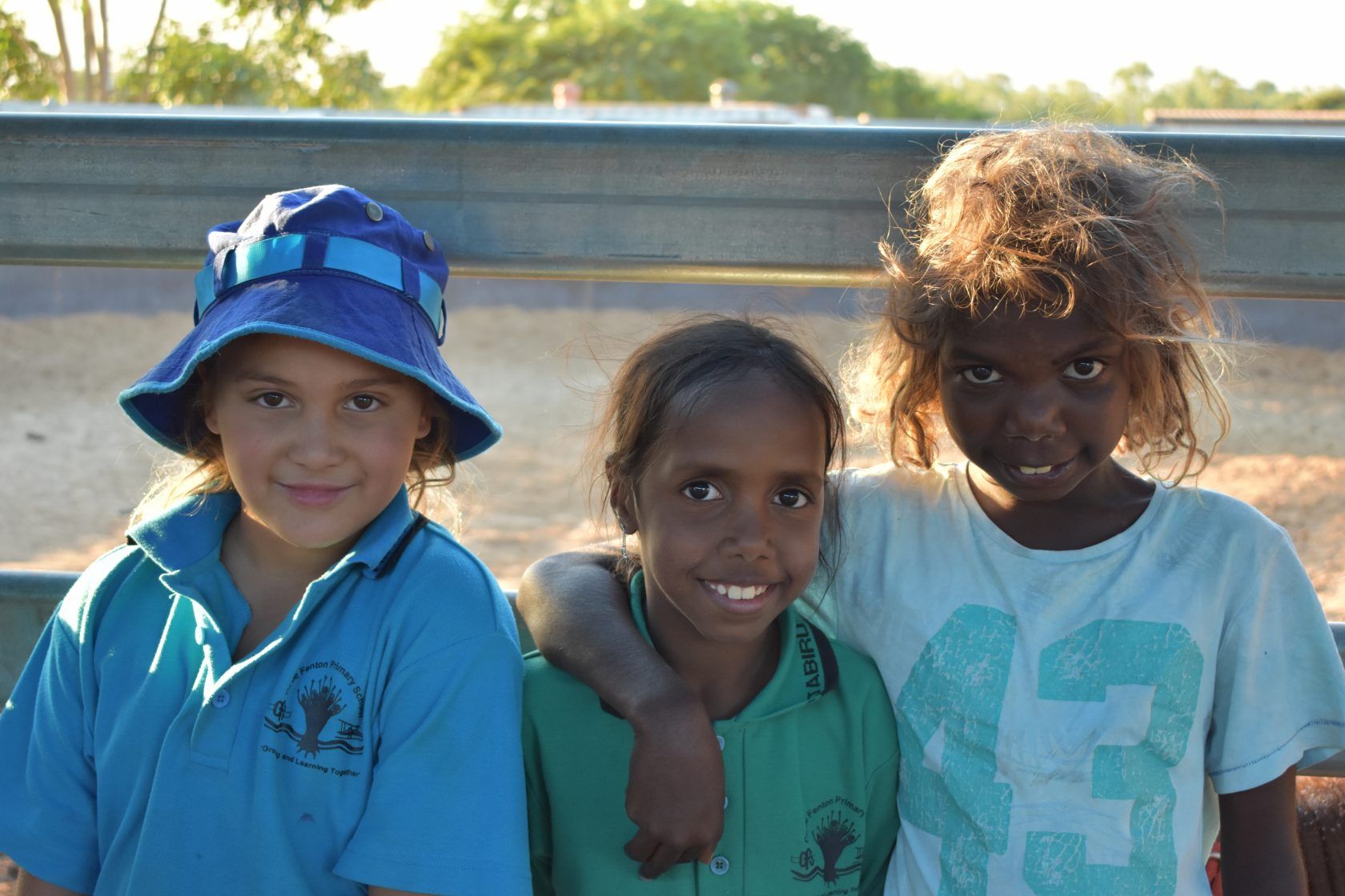 Three young girls are posing for a picture and one of them is wearing a shirt with the number 93 on it