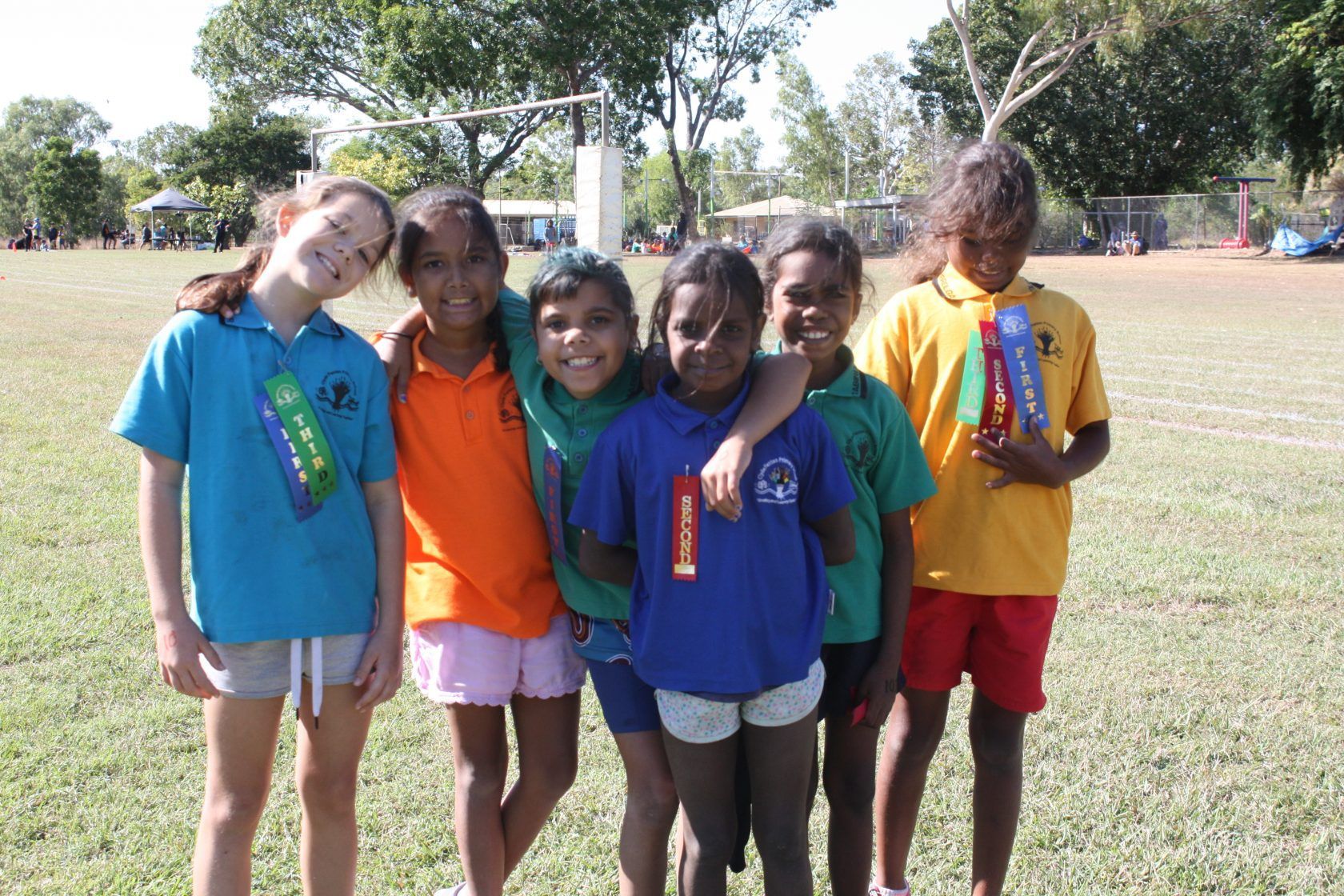 A group of young girls posing for a picture in a field