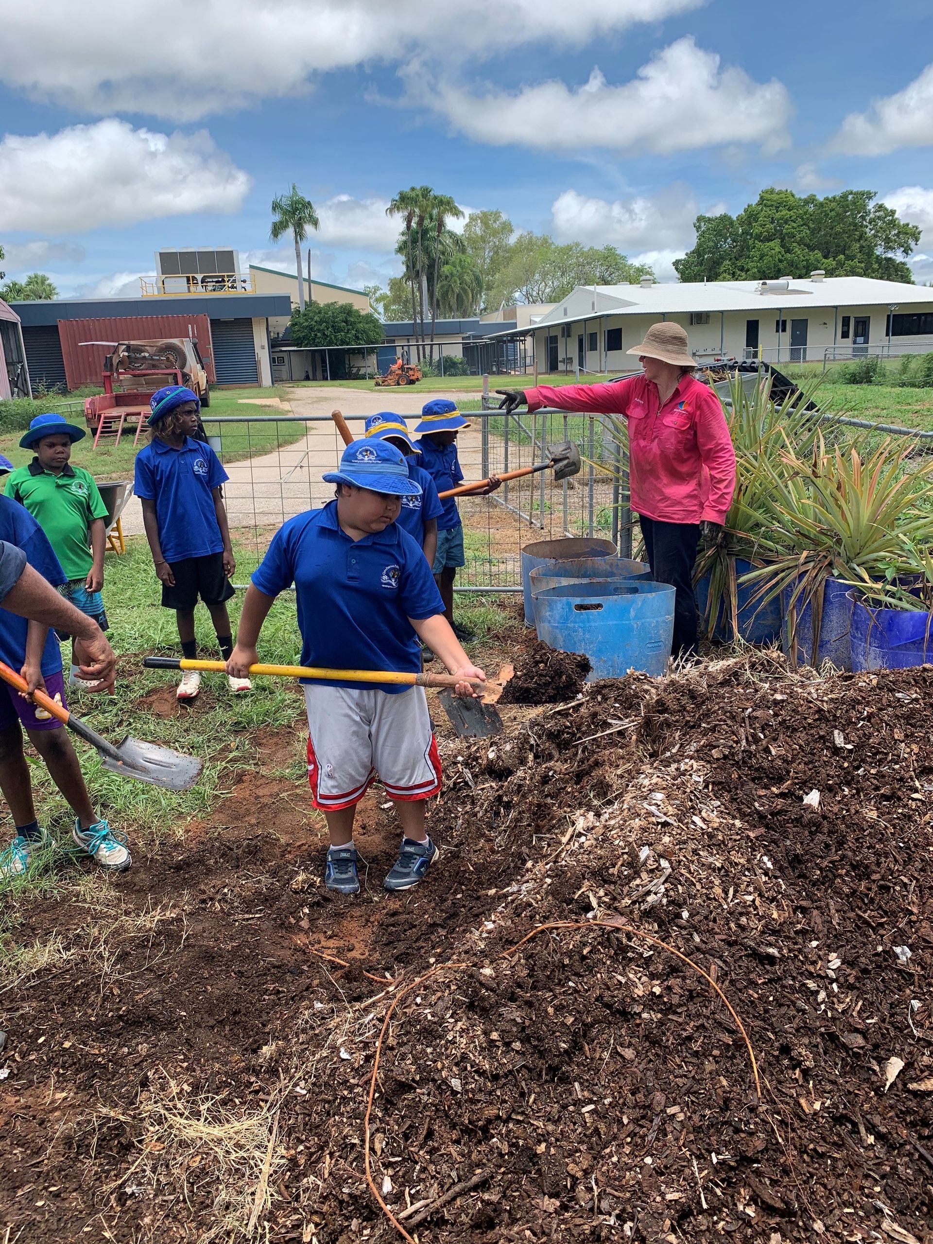 A group of children are digging in a pile of dirt.