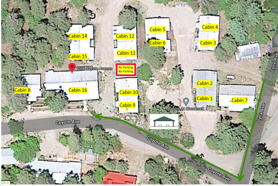 Aerial view of a cabin resort layout with buildings labeled 1-13, an office, and green arrows indicating vehicle access.