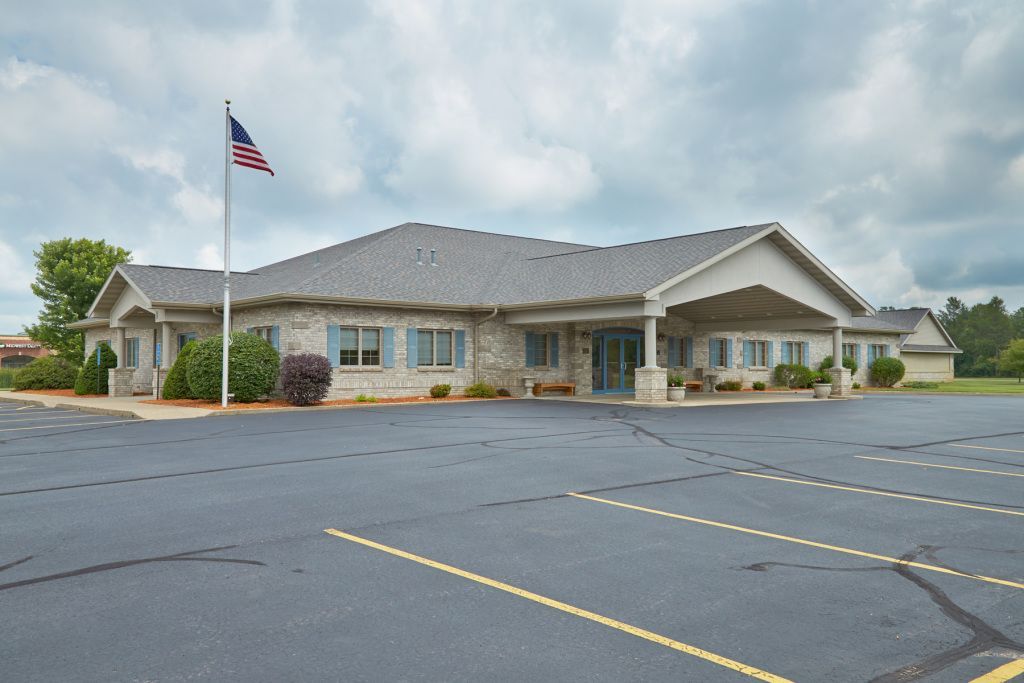 Single-story brick building with an American flag and empty parking lot