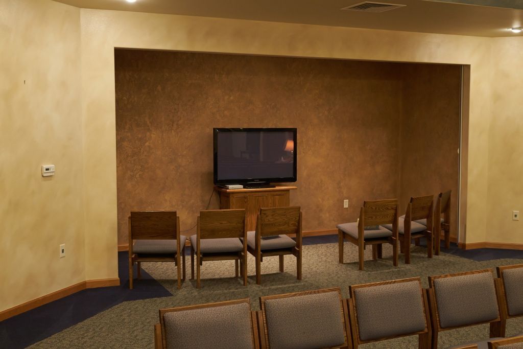Small room with chairs facing a wall-mounted TV in a recessed alcove.