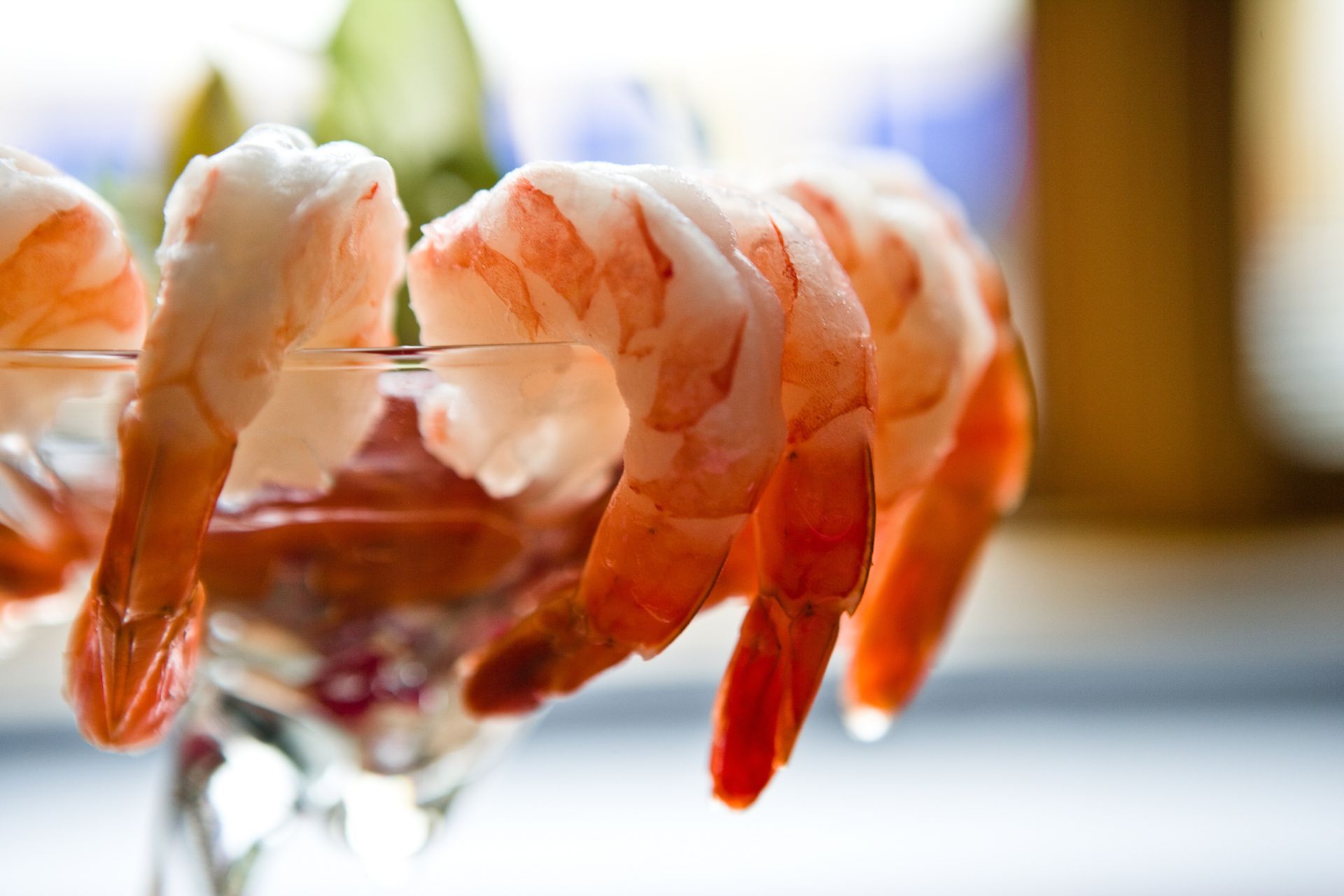 Shrimp cocktail: Cooked shrimp in a glass with red sauce, close-up shot.