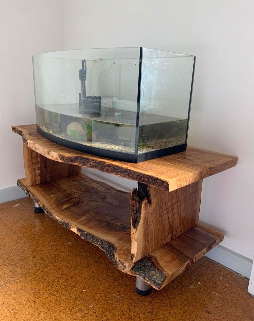 Et akvarium sidder på toppen af ​​et træbord.