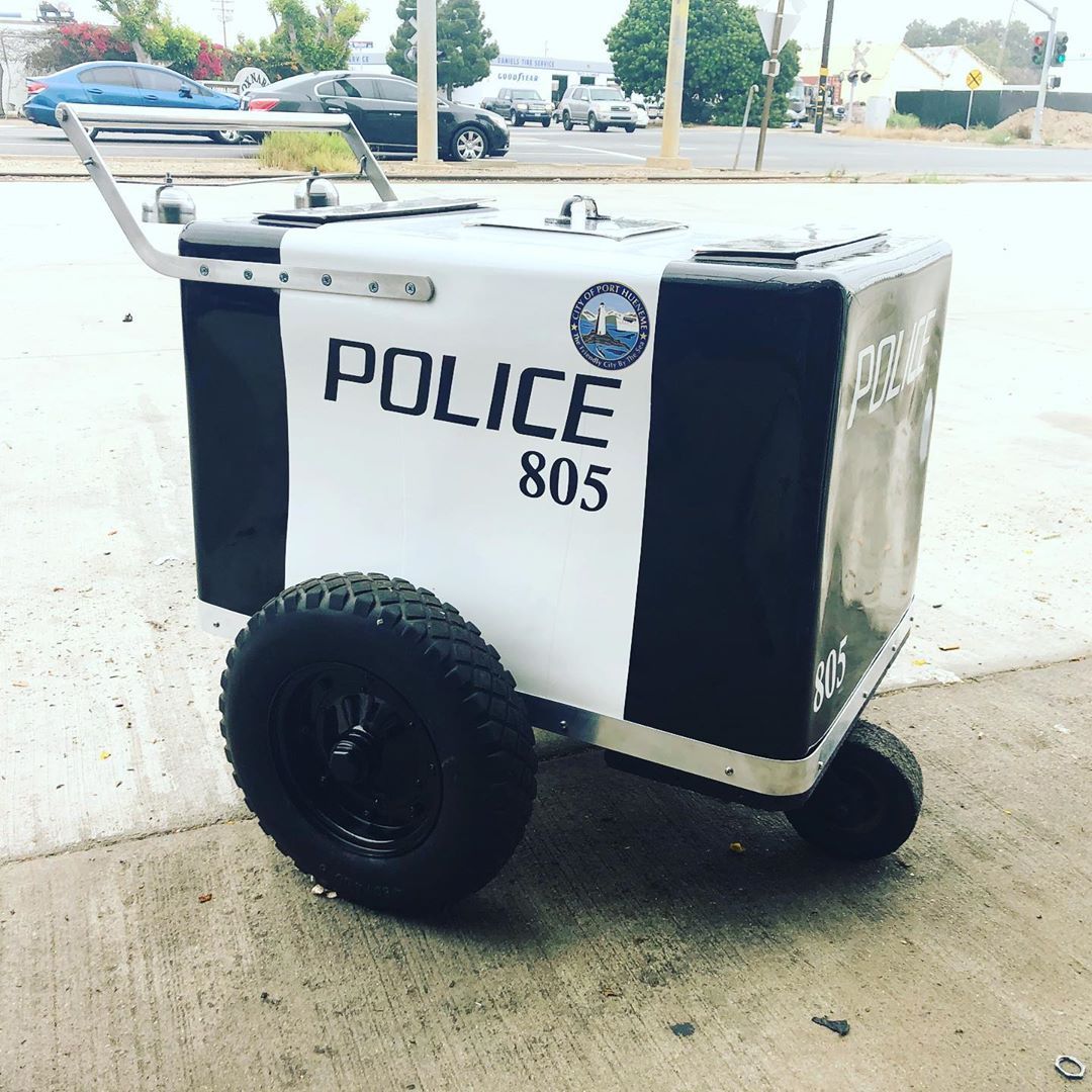 A police box with wheels is parked on the side of the road.