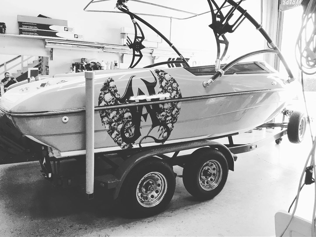 A black and white photo of a boat on a trailer
