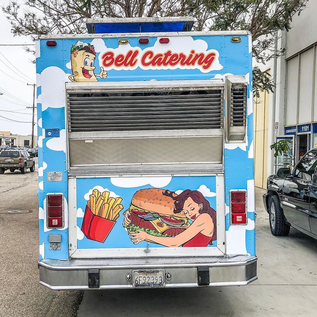 A bell catering food truck is parked in a parking lot
