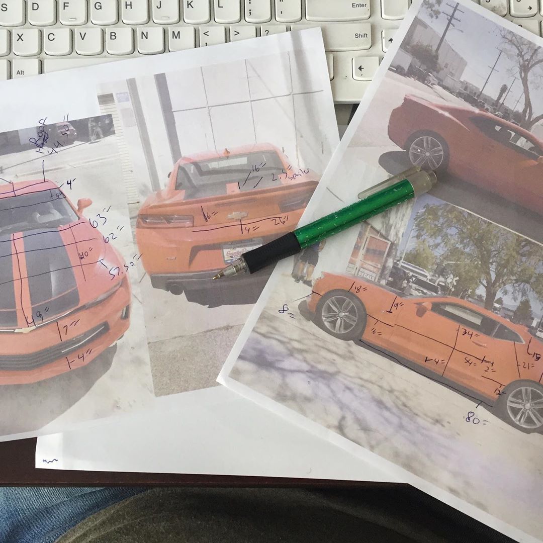 A pen sits on a piece of paper with a picture of a car on it