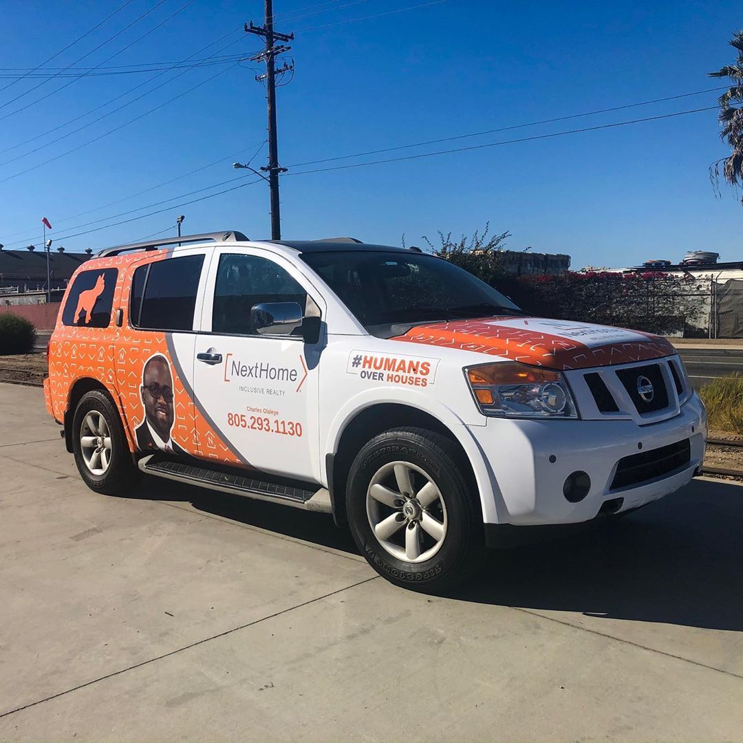 A white and orange suv is parked on the side of the road.