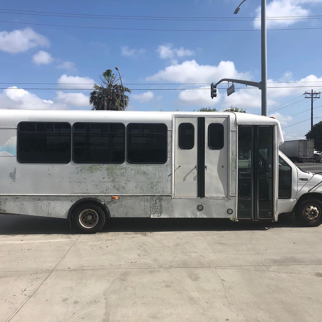 A white bus is parked on the side of the road