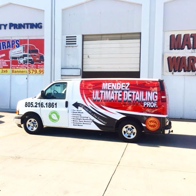 A mendez ultimate detailing van is parked in front of a building