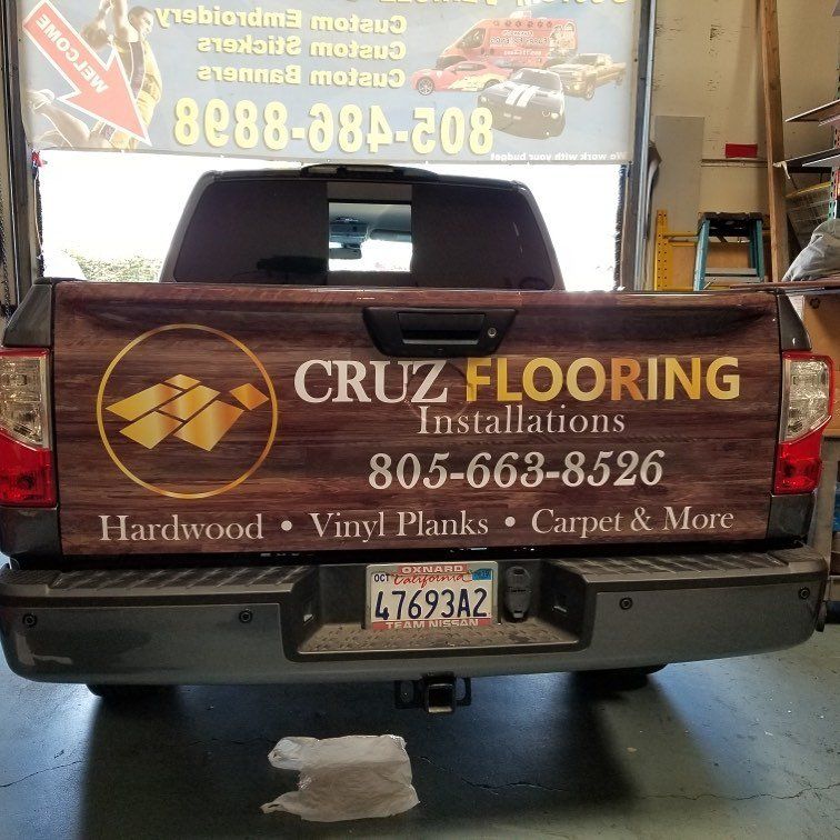 A truck with a sign on the back that says cruz flooring installations