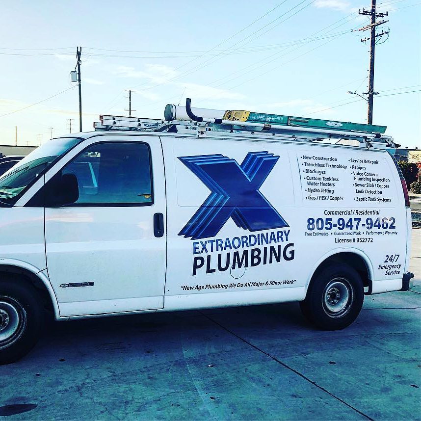 A white van for extraordinary plumbing is parked on the side of the road.