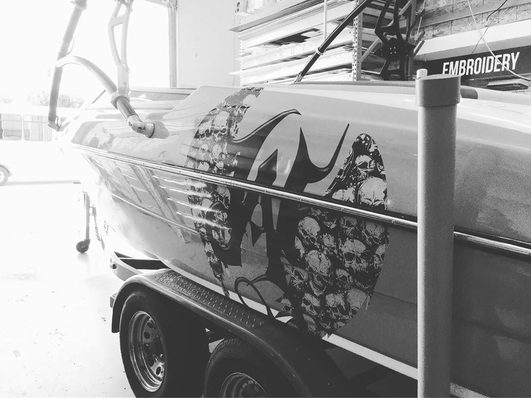 A black and white photo of a boat on a trailer.